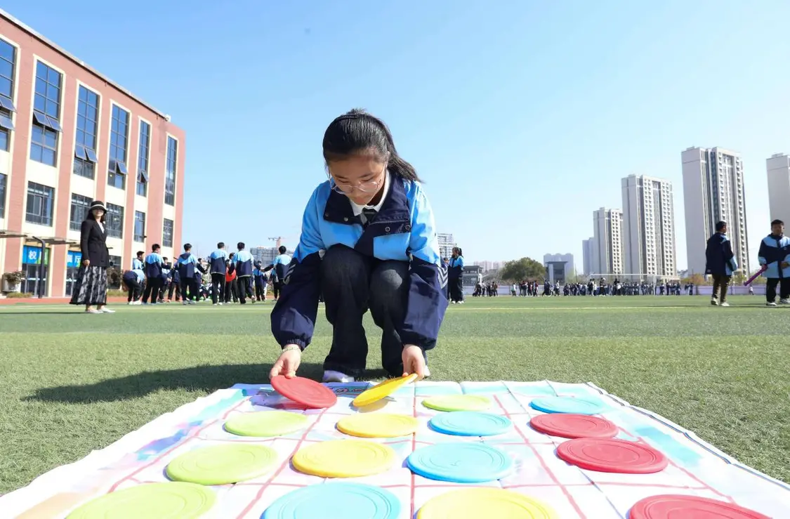 （图为：2025年3月25日，一名学生在安徽省合肥市肥西县上派镇安徽师范大学附属肥西第二中学操场上召开“彩色移盘”心理团辅游戏。）
