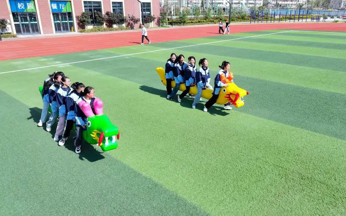 （图为：2025年3月25日，在安徽省合肥市肥西县上派镇安徽师范大学附属肥西第二中学校园内，学生们利用阳光大课间时间在操场上进行“旱地龙舟”趣味运动。）