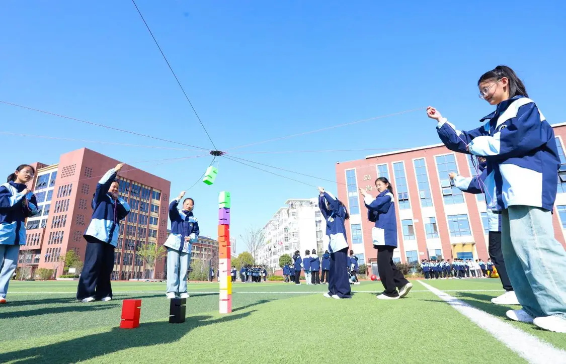 （图为：2025年3月25日，在安徽省合肥市肥西县上派镇安徽师范大学附属肥西第二中学校园内，学生们利用阳光大课间时间在操场上召开“合力筑塔”心理团辅游戏。）