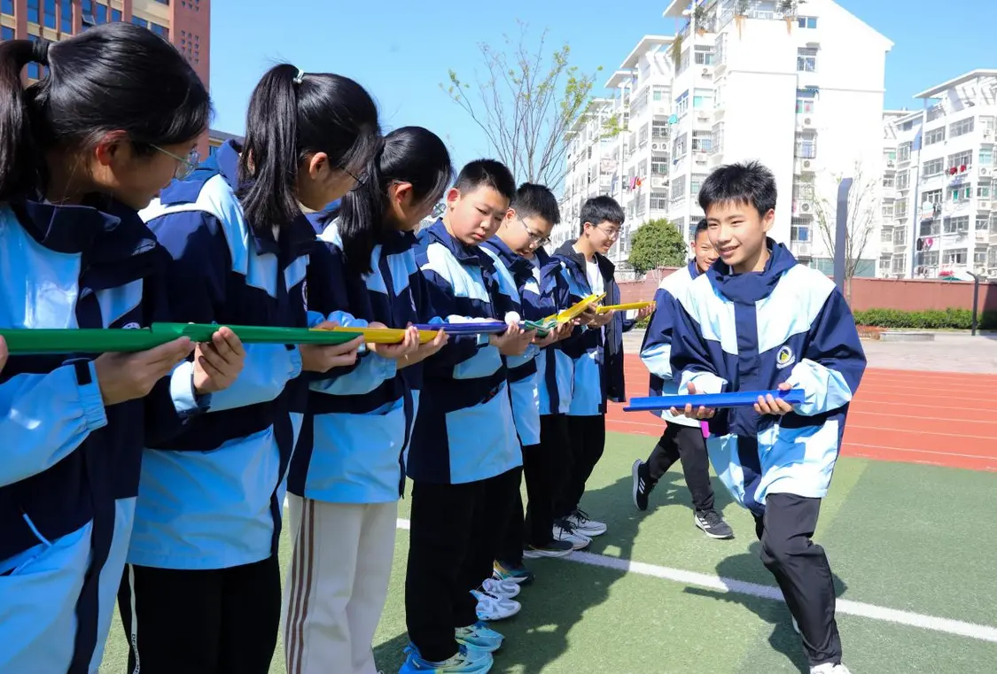 （图为：2025年3月25日，在安徽省合肥市肥西县上派镇安徽师范大学附属肥西第二中学校园内，学生们利用阳光大课间时间在操场上召开“球行万里”心理团辅游戏。）